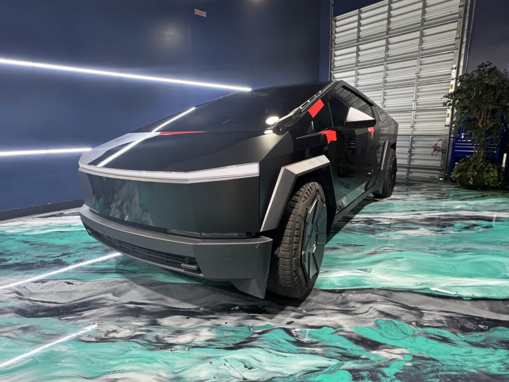 Tesla Cybertruck wrapped in matte camo vinyl wrap parked outdoors, showcasing premium car wrap installation and custom vehicle customization by a luxury car wrap shop in Orlando FL.